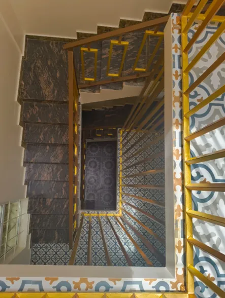 Stairwell seen from above, showing patterned tiling and railing detail